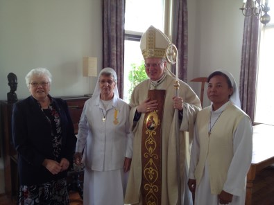 Zuster André met onderscheiding; naast haar twee medezusters