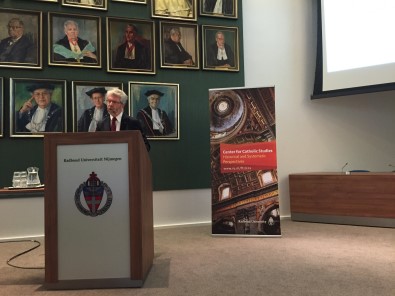 Prof. dr. Herwi Rikhof tijdens zijn lezing (op de achtergrond de rectoren magnifici van Nijmegen, onder hen Titus Brandsma)