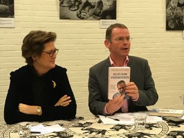 Colm Dekker toont het boek. Naast hem mw. Hilde Kieboom