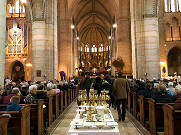 De gelovigen stromen binnen voor de Chrismamis