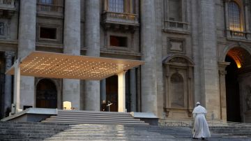 Paus Franciscus loopt door de stromende regen naar het podium op het lege Sint-Pietersplein