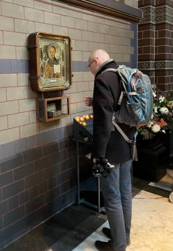 Een gelovige bij de icoon en de reliek van de H. Nicolaas in de basiliek