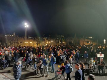 Vrijwilligers rijden de rolstoelen bij de lichtprocessie